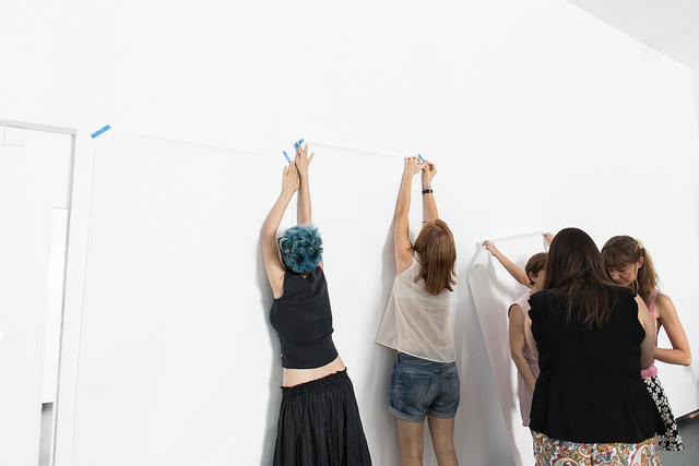 Grupos de personas pega cartulinas en la pared para comenzar un taller
